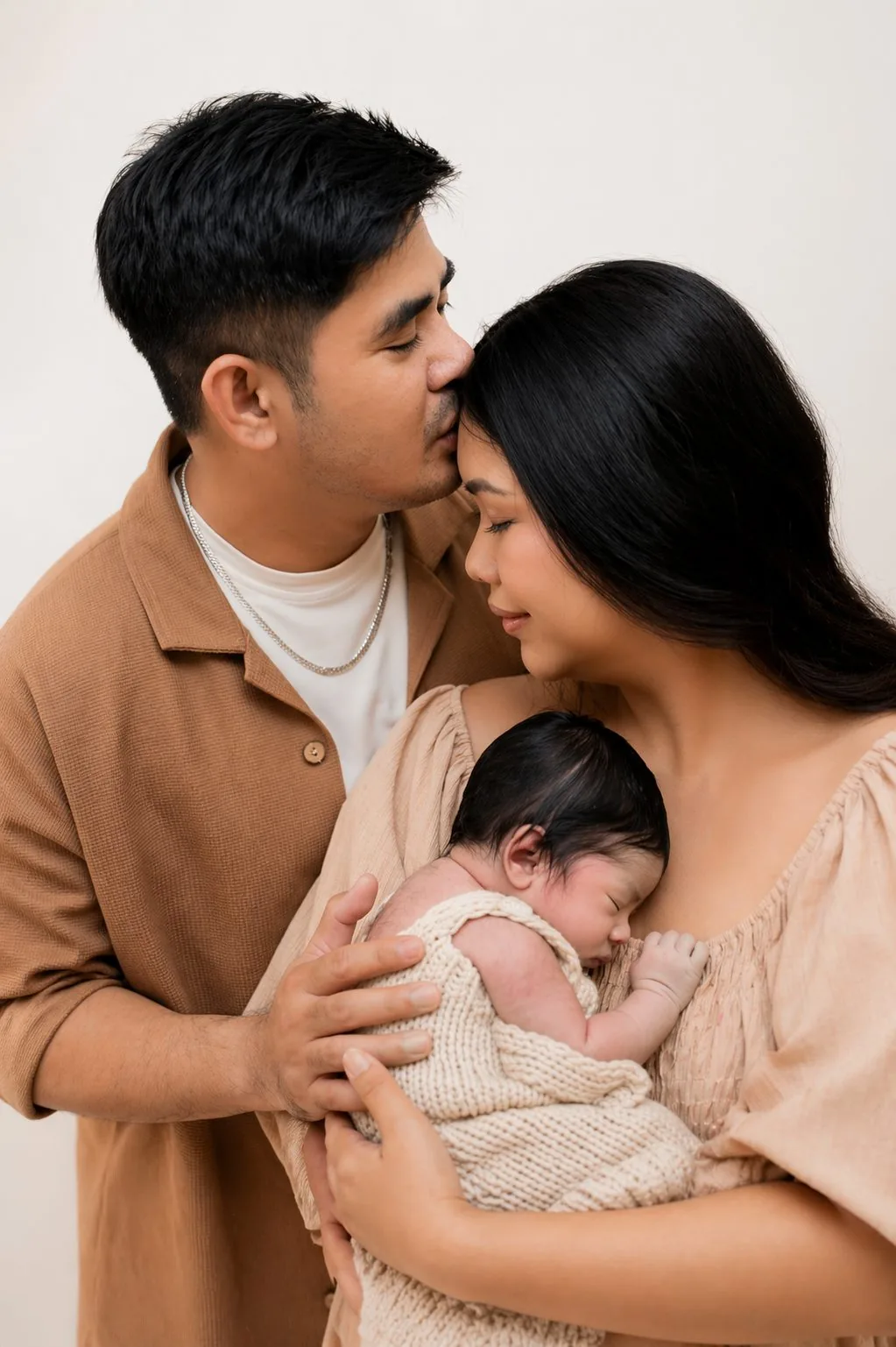 Couple holding their newborn baby during a family photoshoot