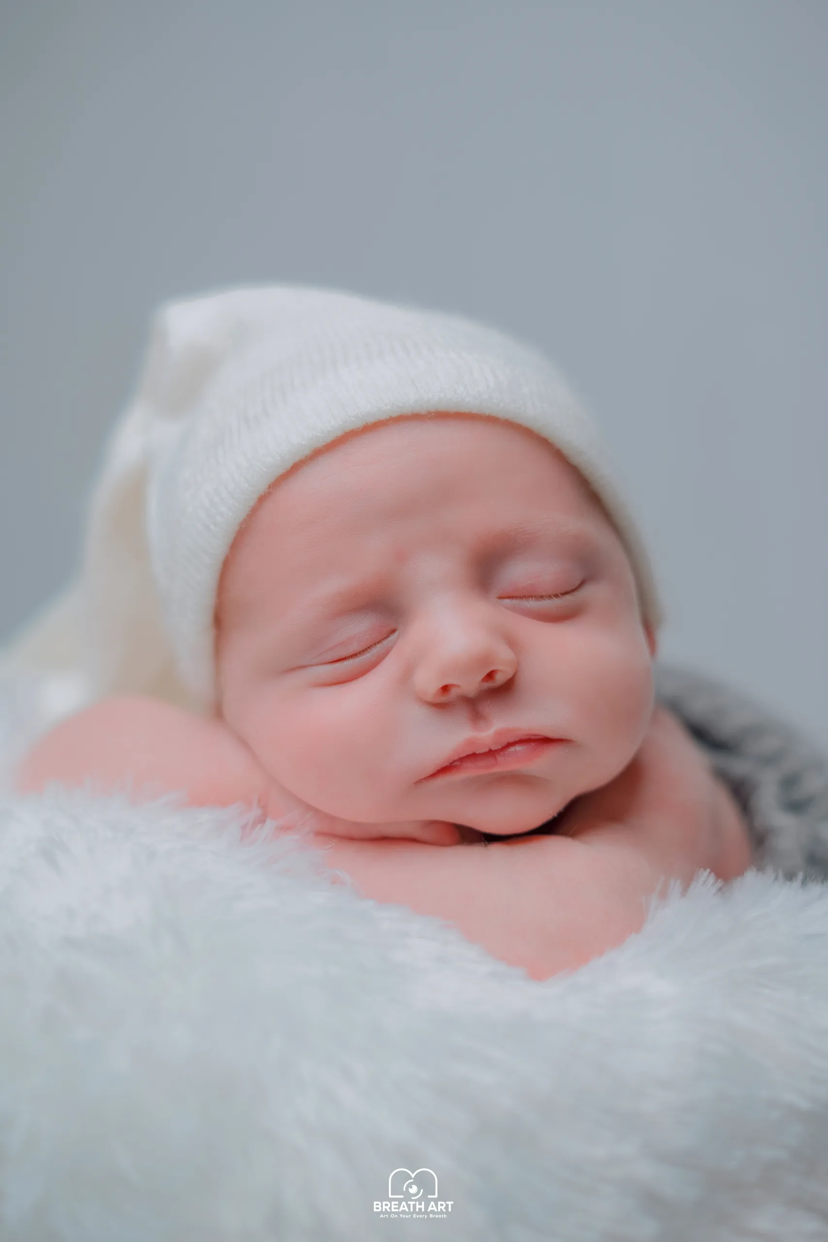 Newborn sleeping in a white knitted hat, naturally edited