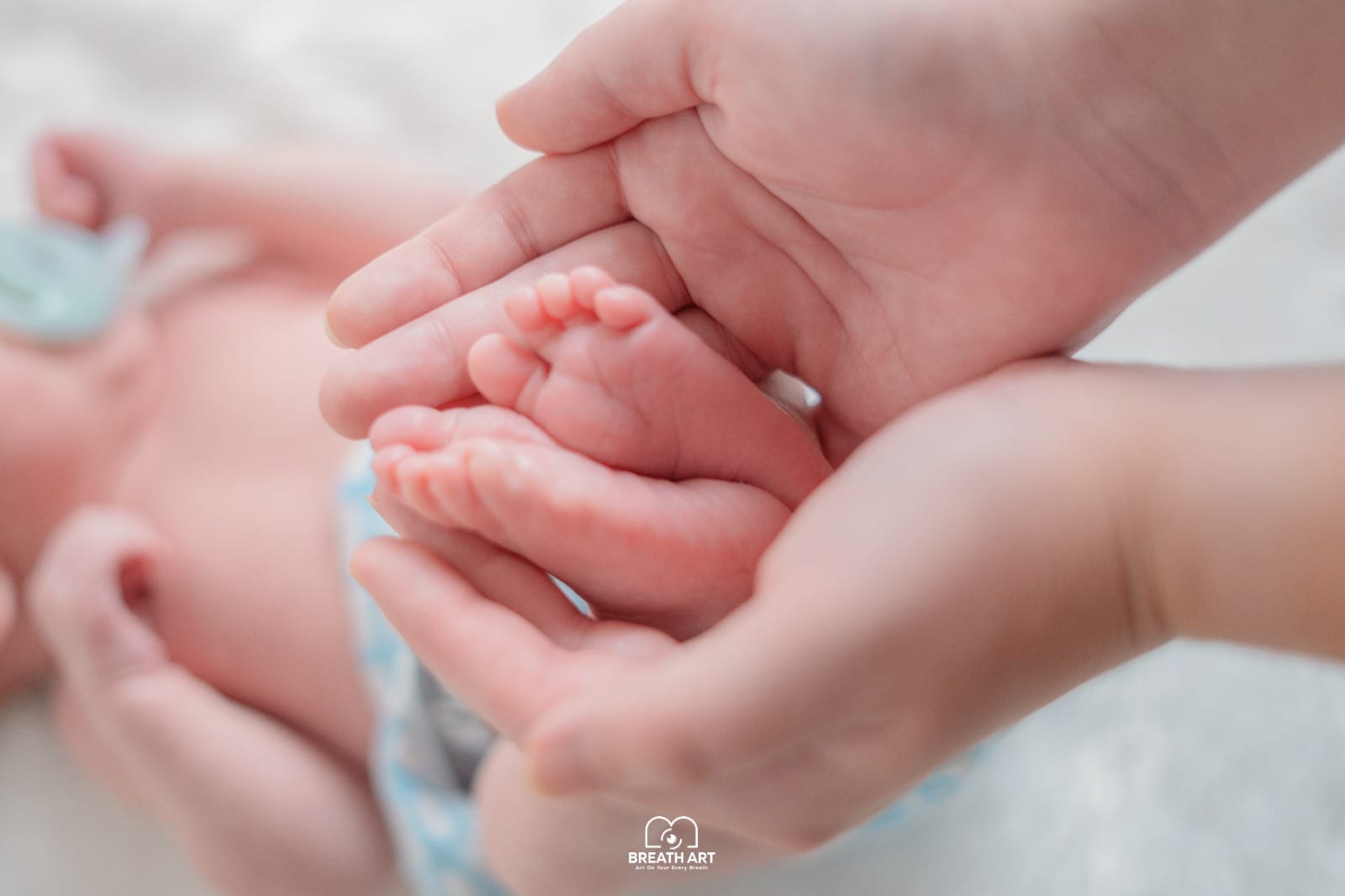 Close-up of newborn baby feet held in parents hands